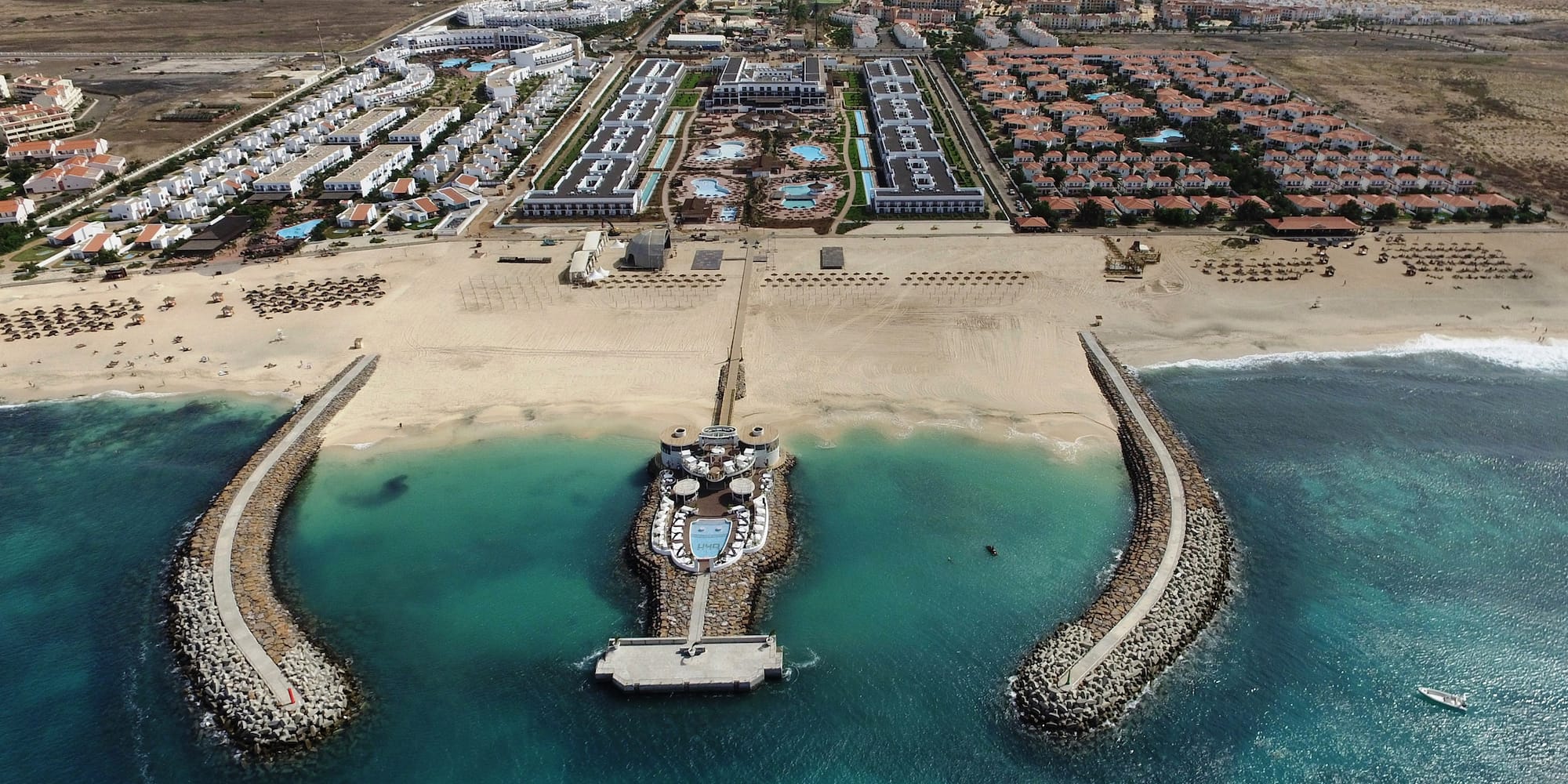 a beach with buildings and a body of water