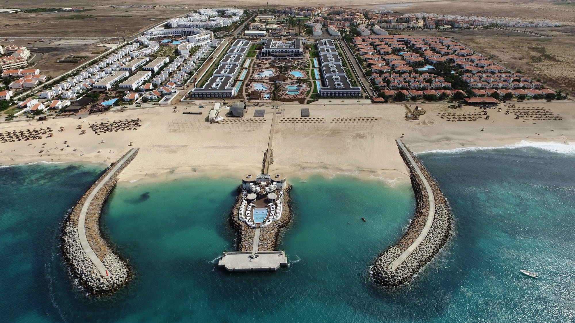 a beach with buildings and a body of water