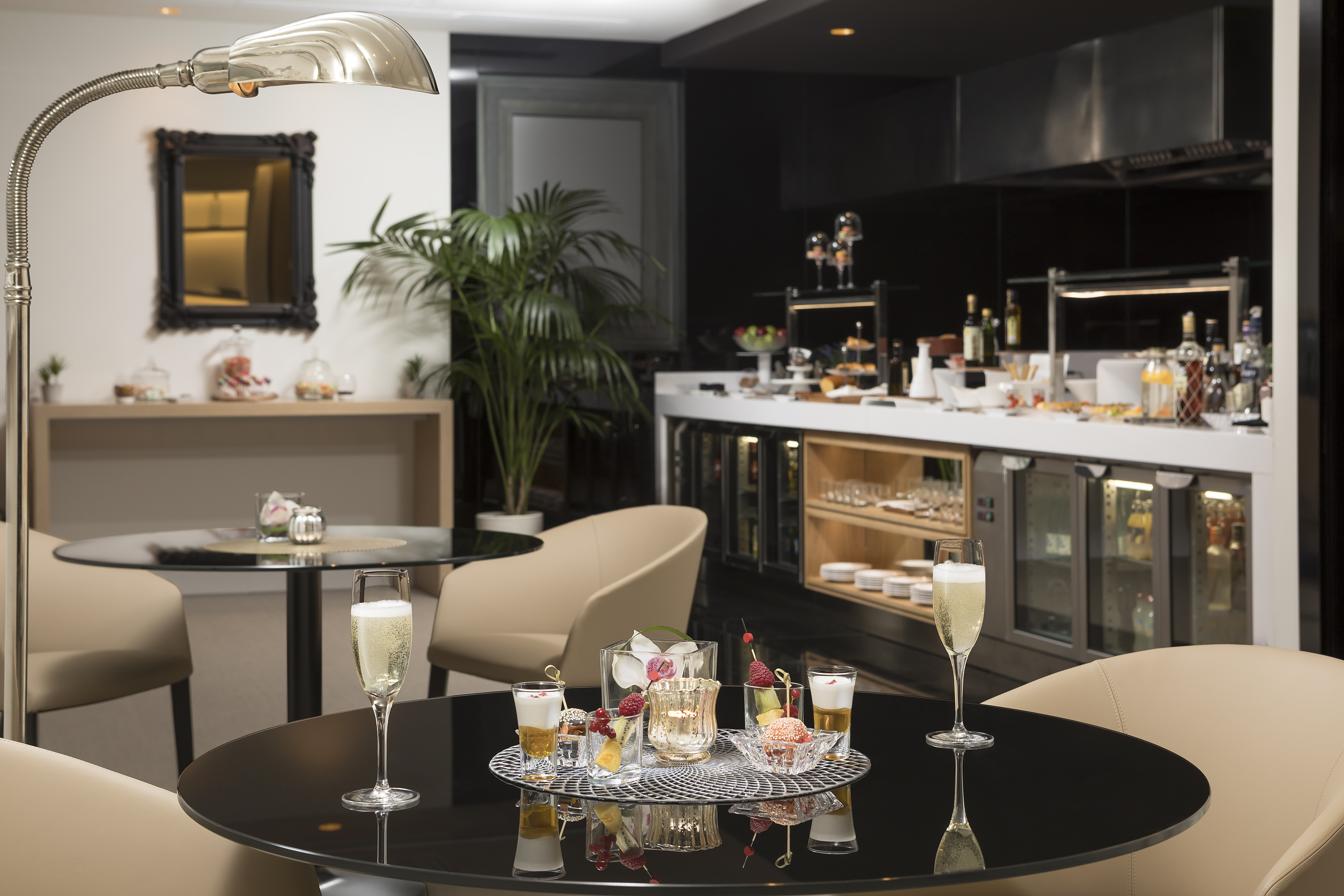 Elegant hotel lounge with champagne, small desserts, and a gourmet buffet.