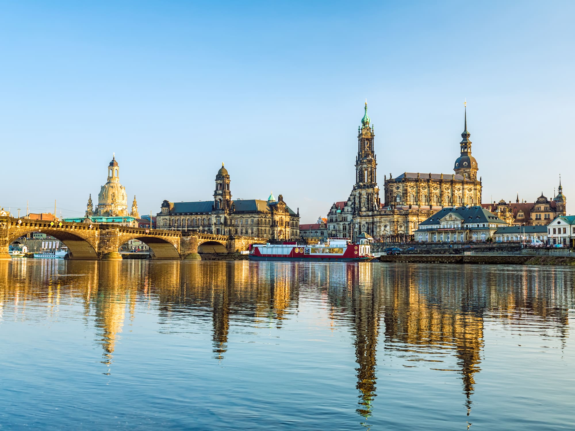 Panoramic Dresden skyline with historic buildings reflected in the Elbe River.