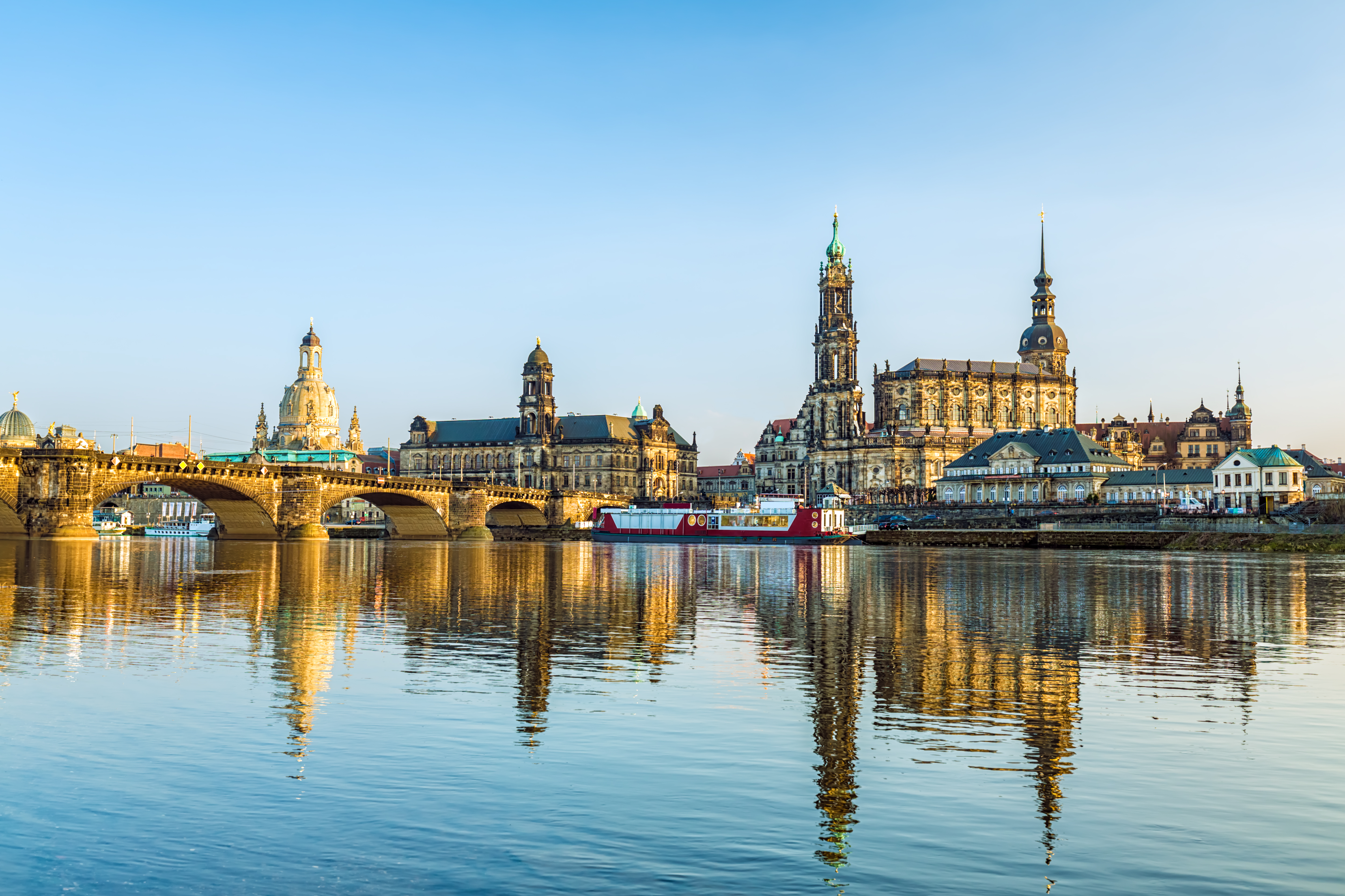 Panoramic Dresden skyline with historic buildings reflected in the Elbe River.