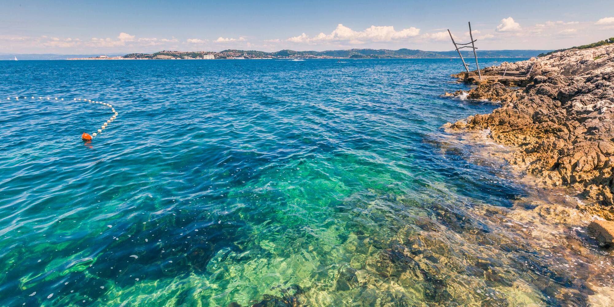 a body of water with rocks and a dock