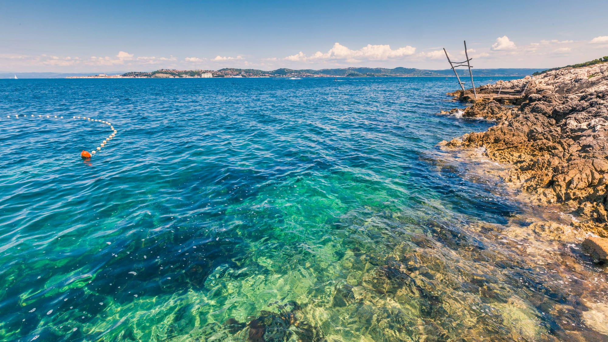 a body of water with rocks and a dock