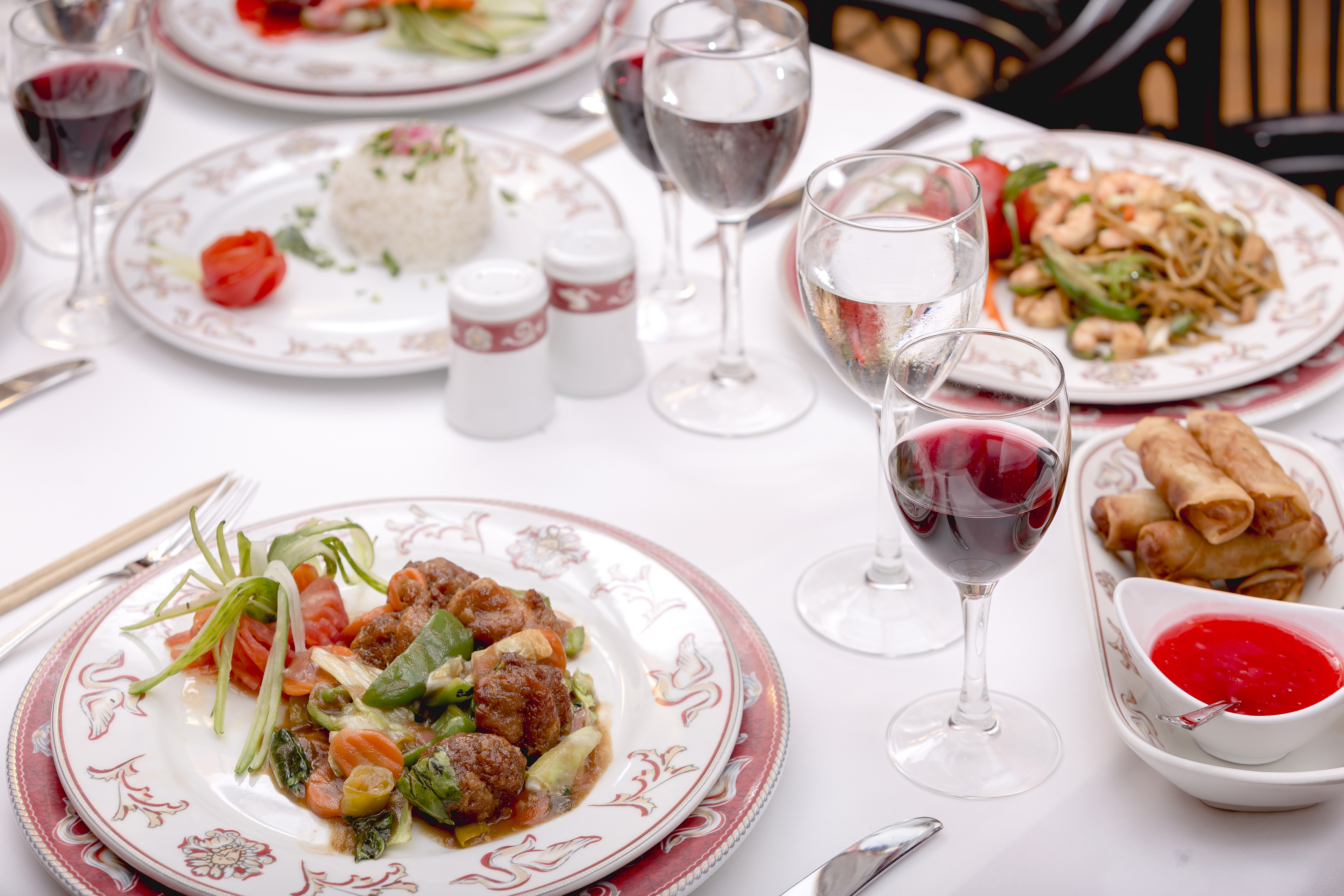 a table with plates of food and wine glasses