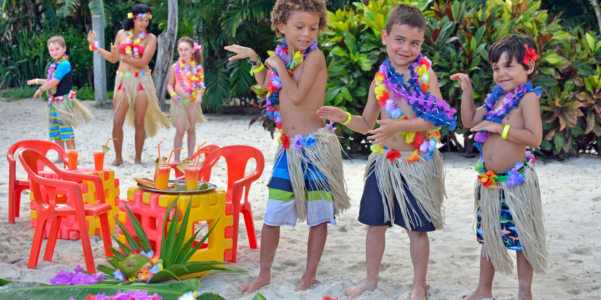 a group of kids wearing grass skirts and flowers
