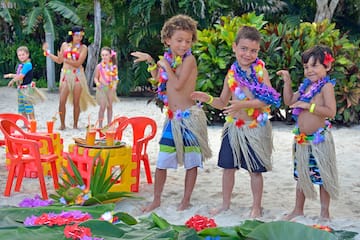 a group of kids wearing grass skirts and flowers