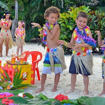 a group of kids wearing grass skirts and flowers