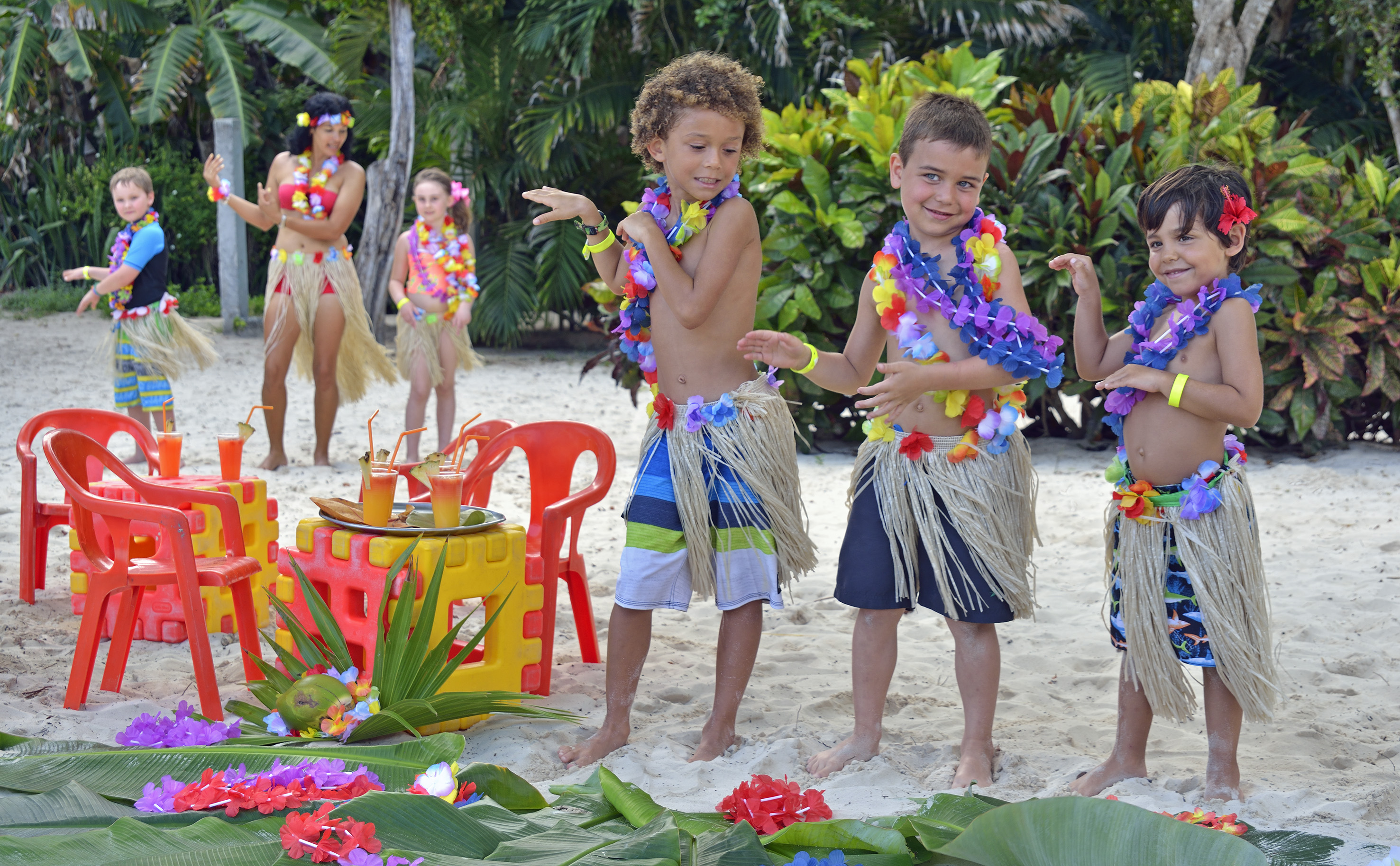 a group of kids wearing grass skirts and flowers