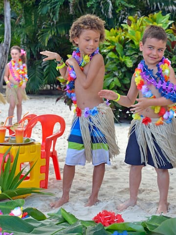 a group of kids wearing grass skirts and flowers