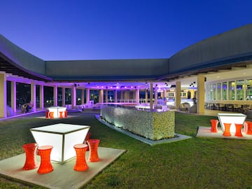 a building with a large patio and a large building with a pool and tables