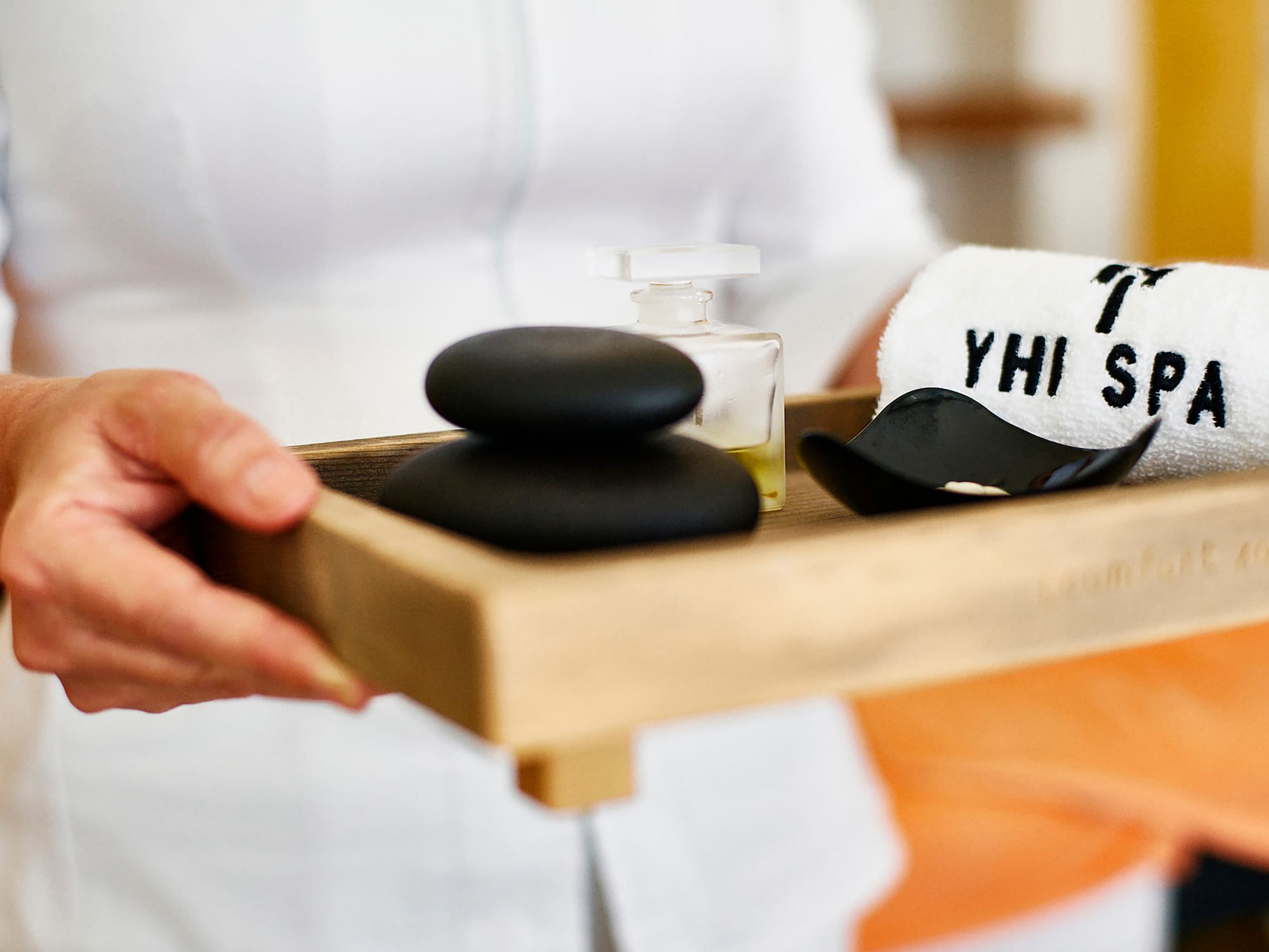 a person holding a tray of black stones