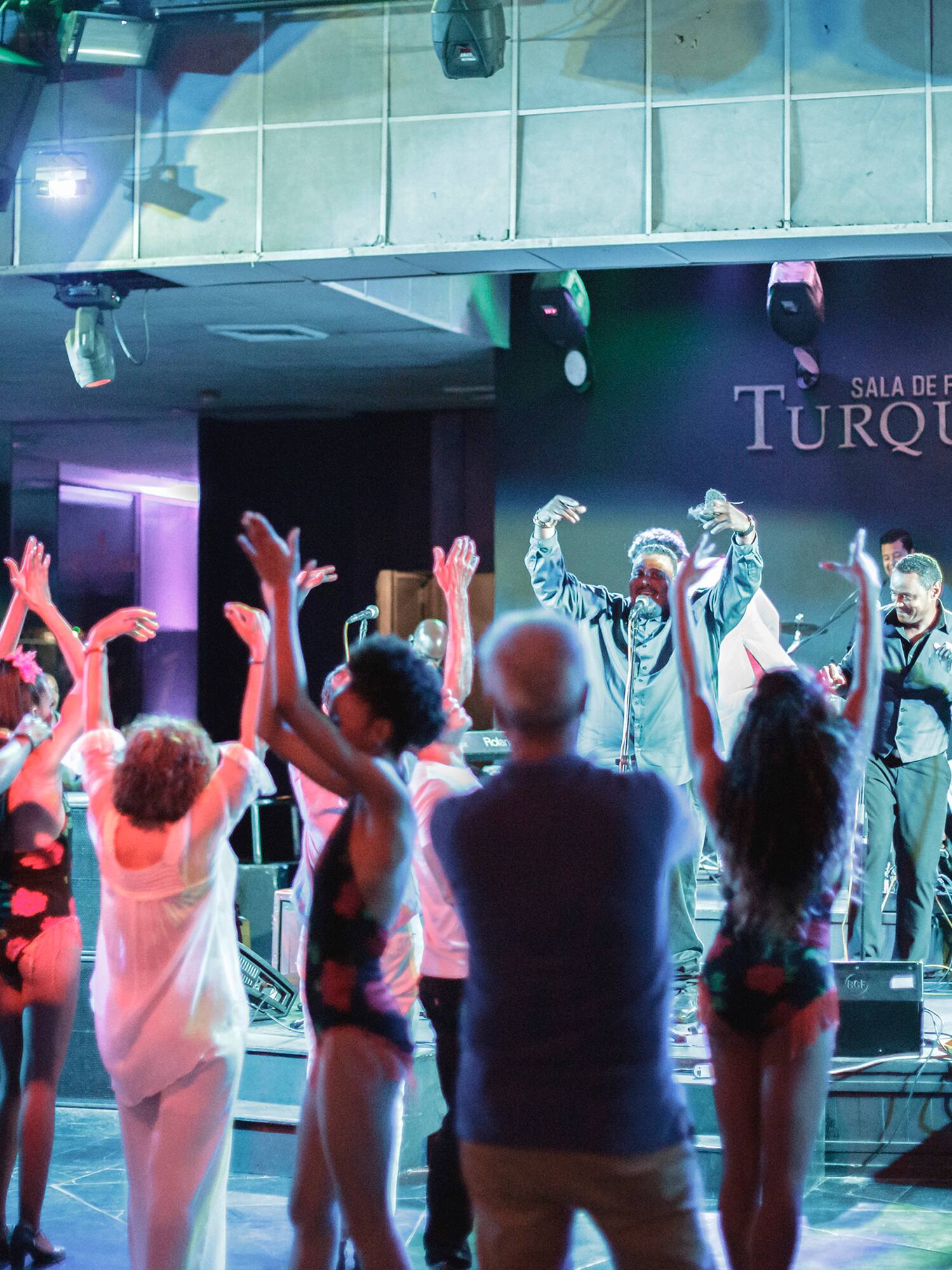 a group of people on a stage with a man on a stage with hands up