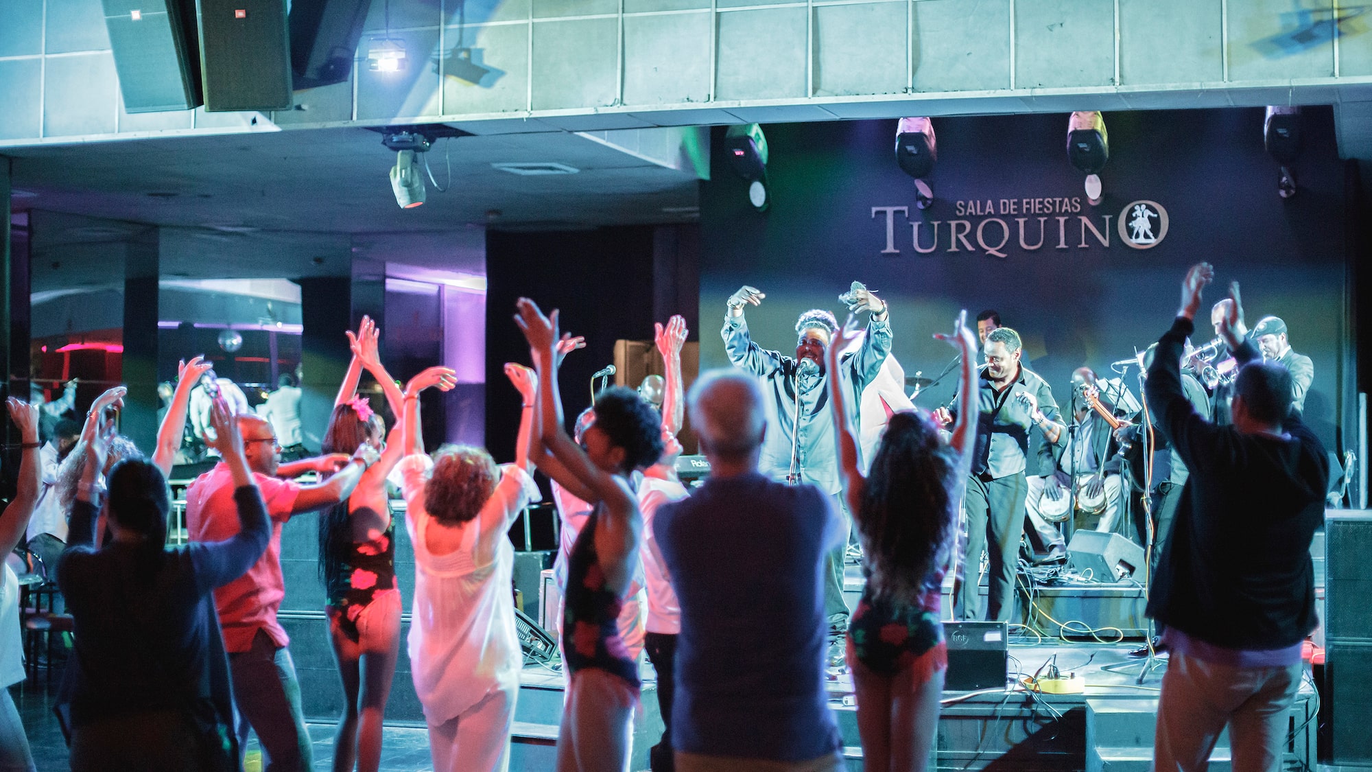 a group of people on a stage with a man on a stage with hands up