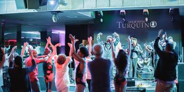 a group of people on a stage with a man on a stage with hands up