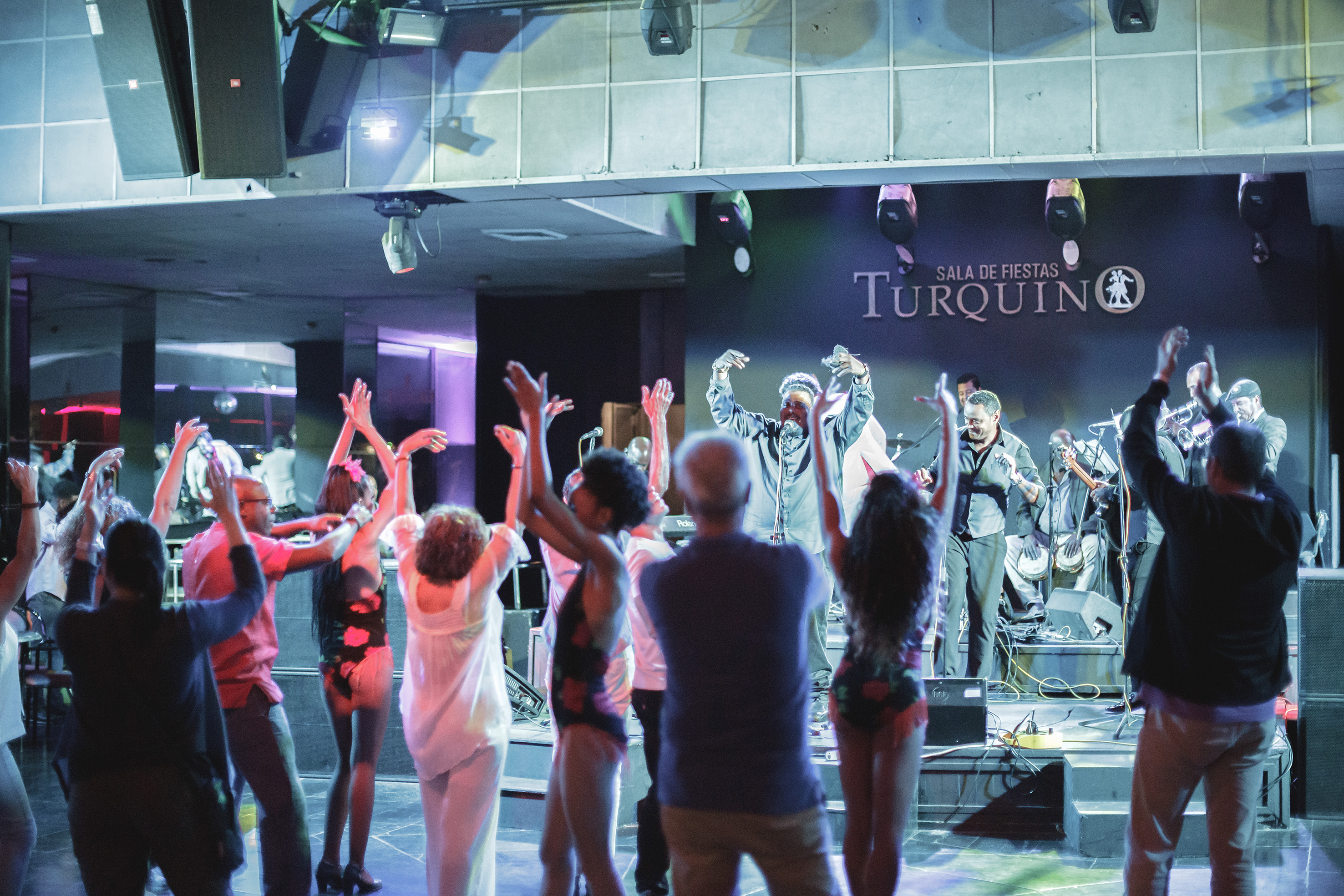 a group of people on a stage with a man on a stage with hands up