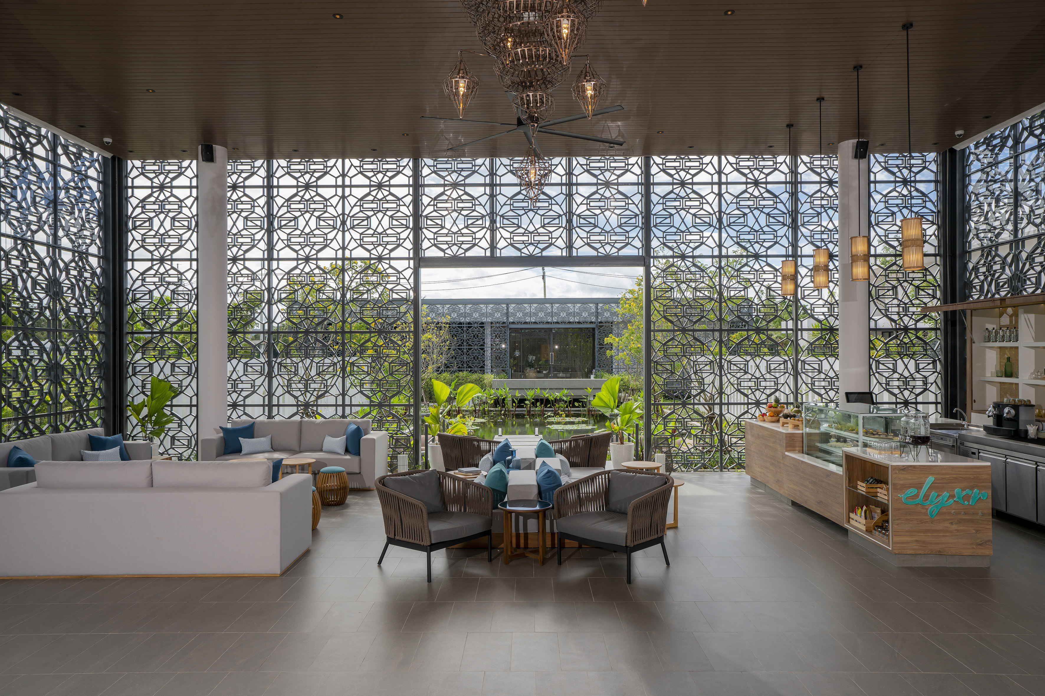 Resort lounge with modern seating, intricate screens, and cafe counter.