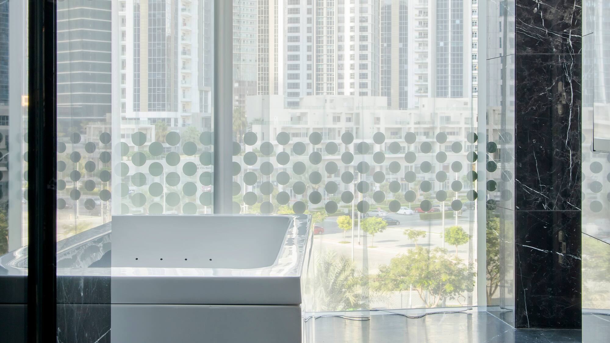a bathtub in a room with a window and a city view