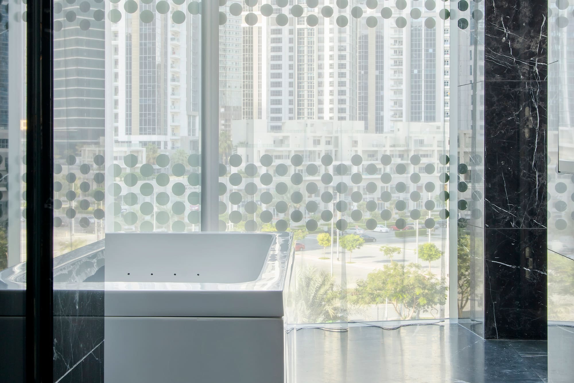 a bathtub in a room with a window and a city view