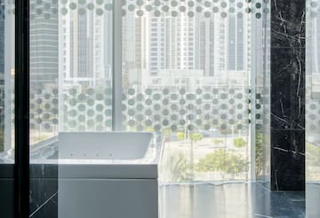a bathtub in a room with a window and a city view