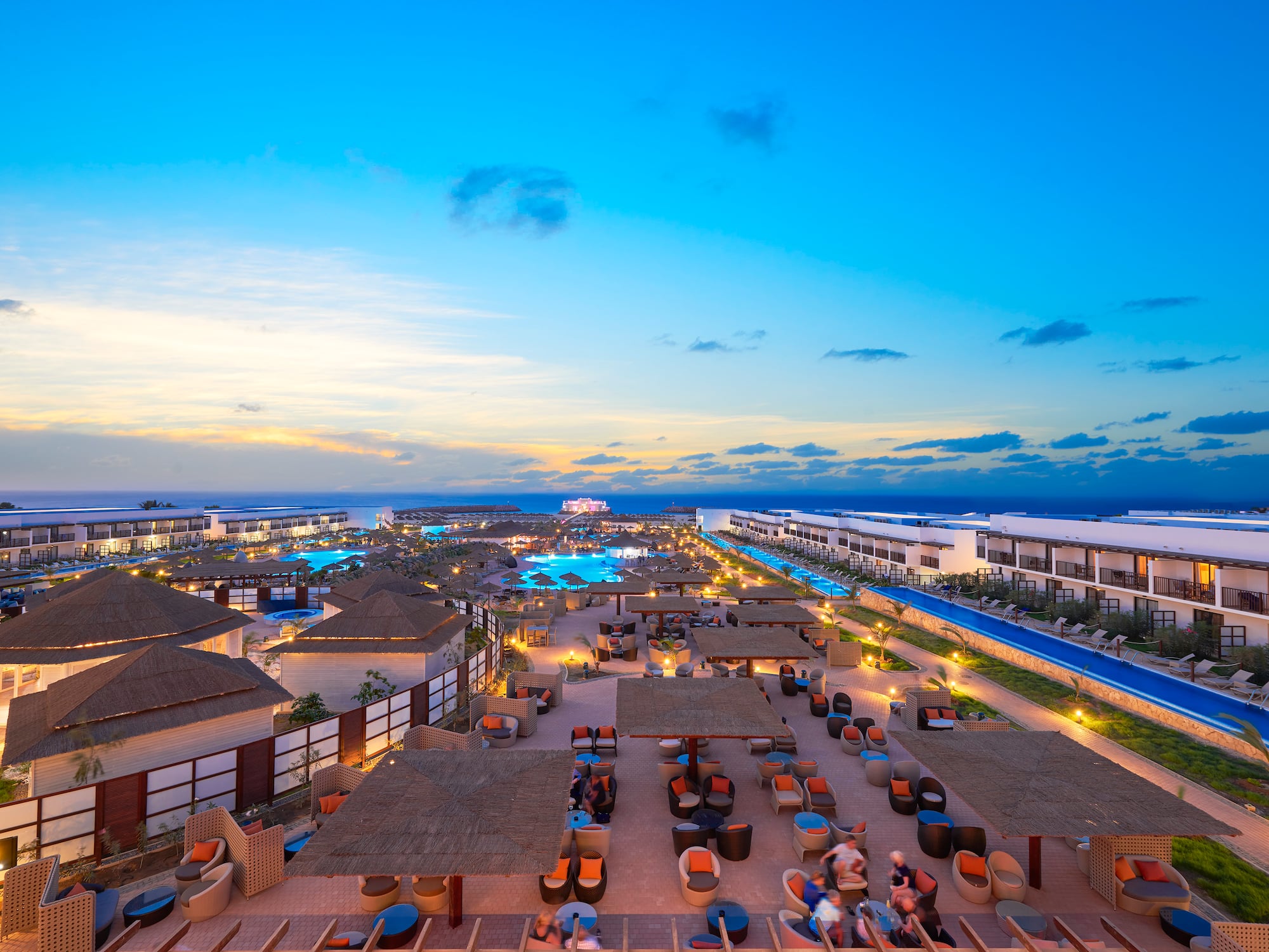 a group of buildings with chairs and tables in a resort