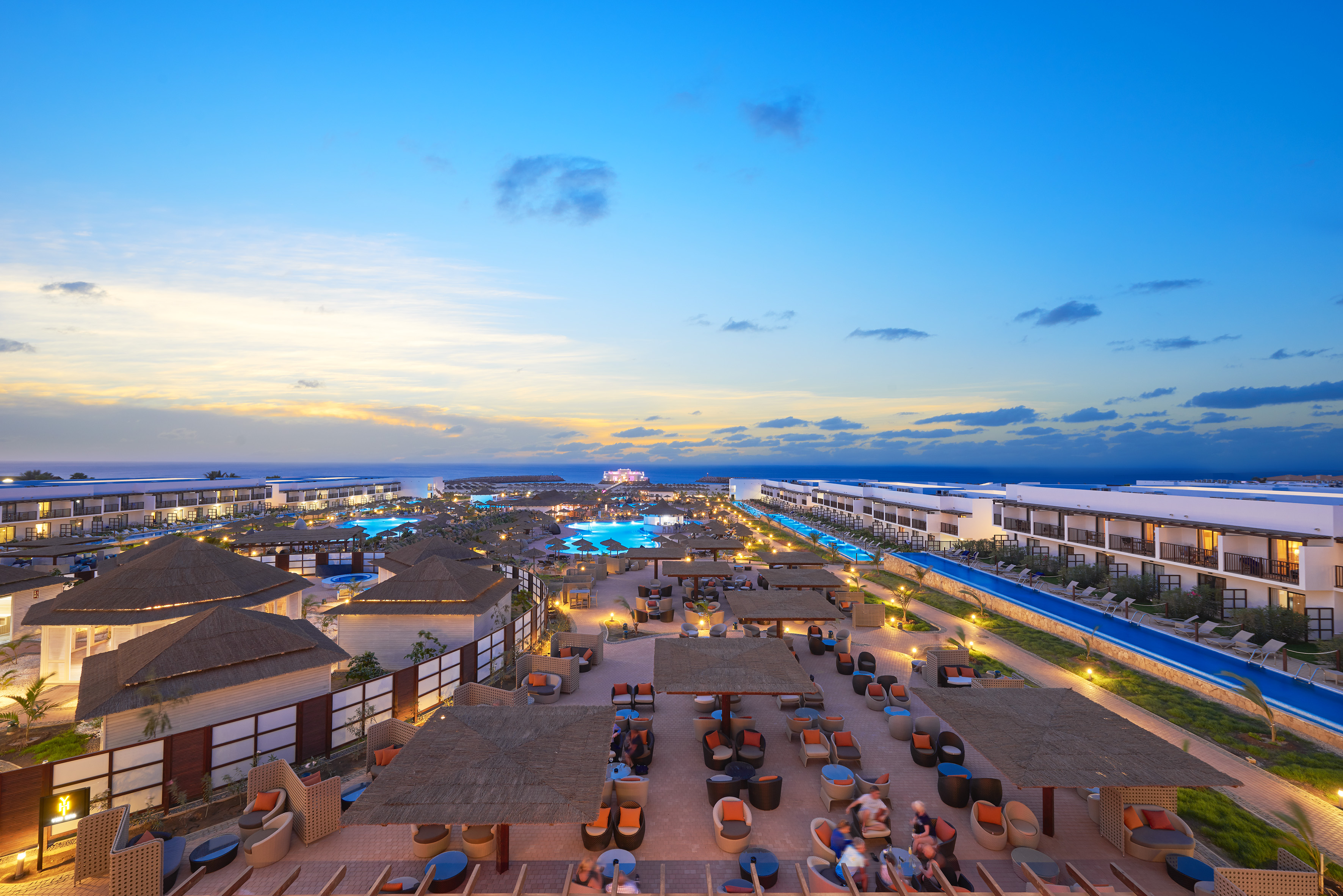 a group of buildings with chairs and tables in a resort