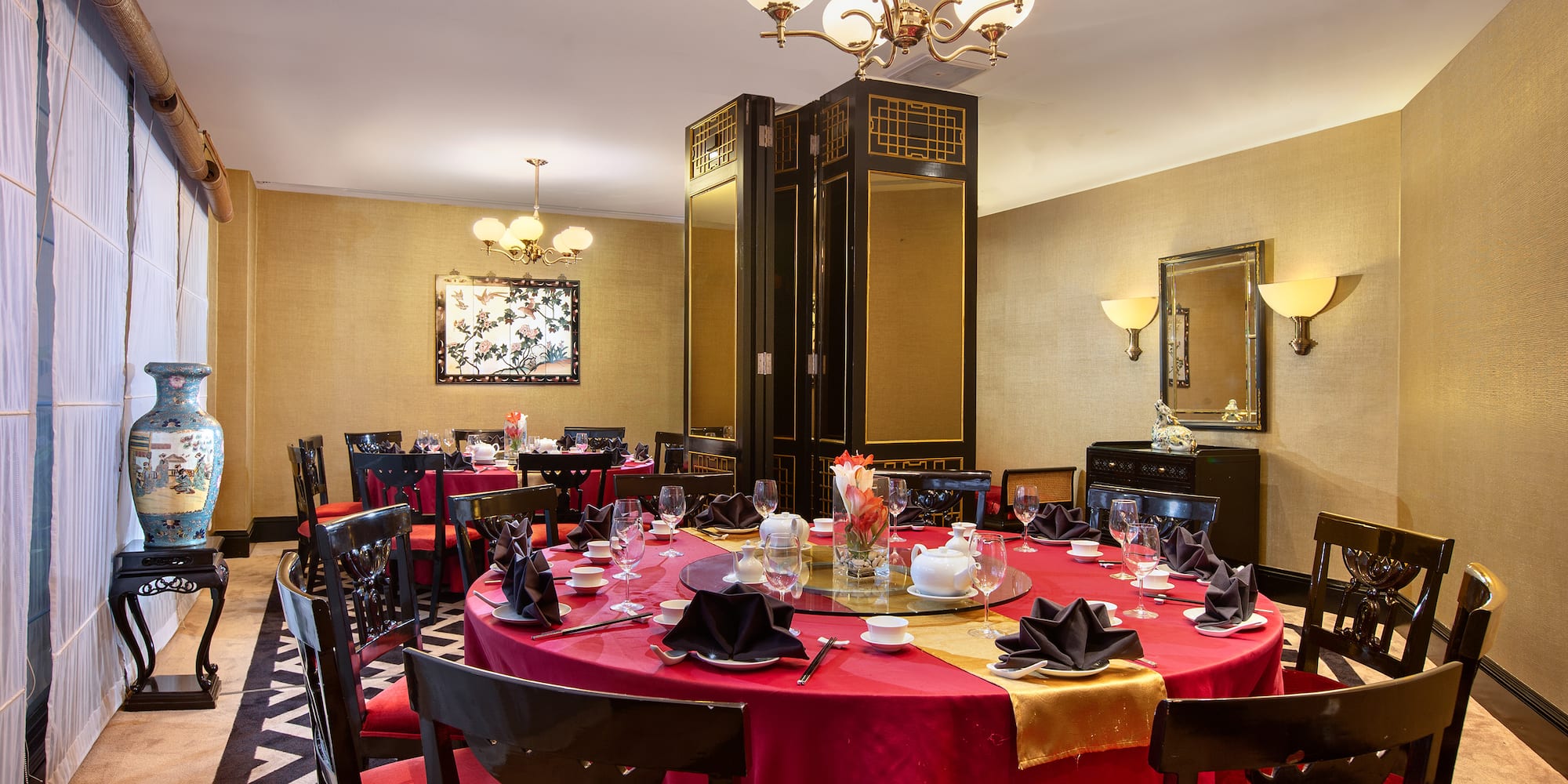 a room with a red tablecloth and chairs