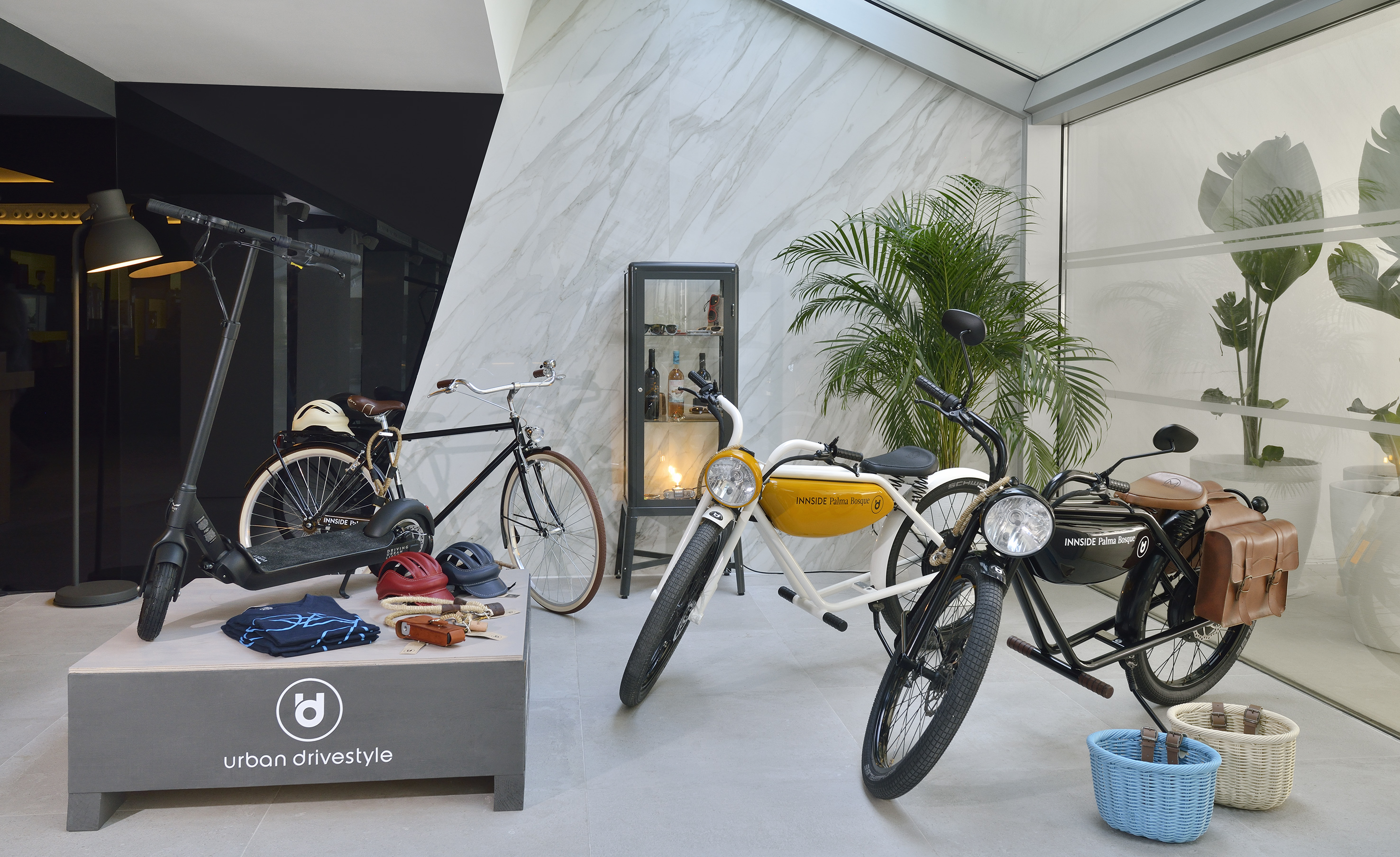Urban drivestyle showroom with electric scooter, classic bicycle, and vintage e-bikes.