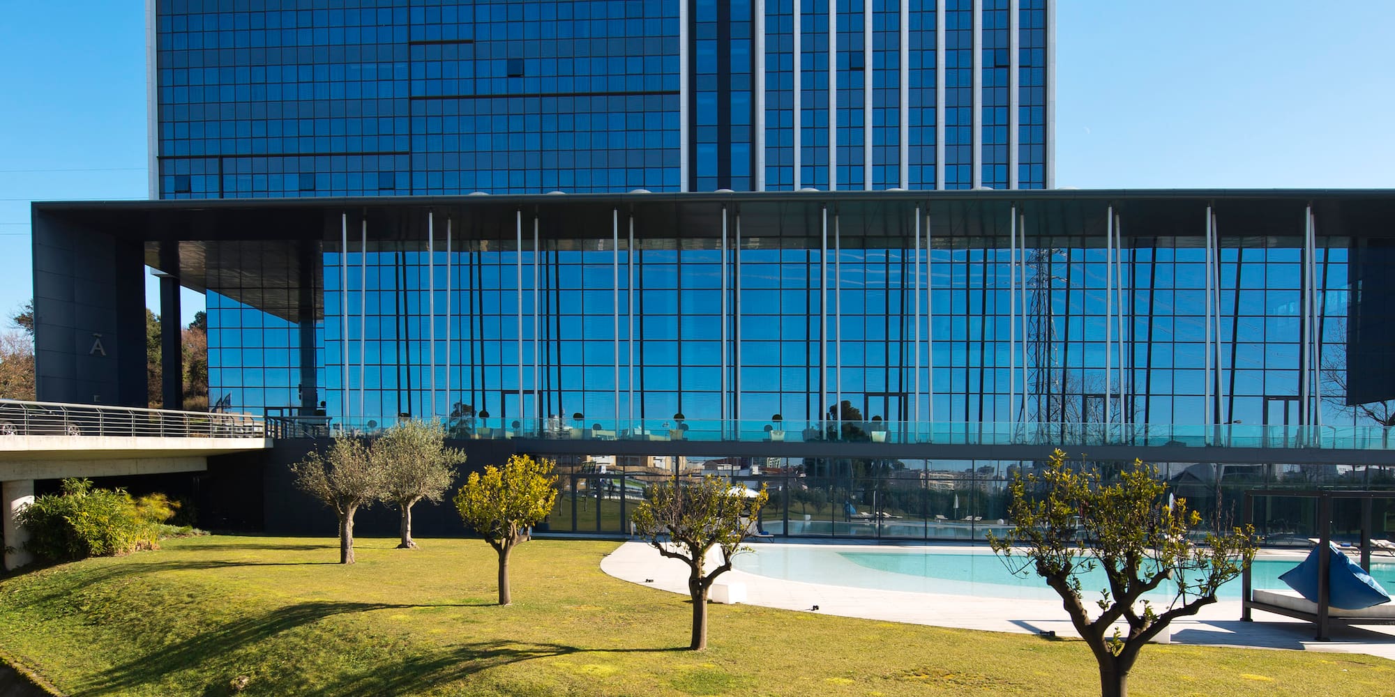 a bridge over grass and a building