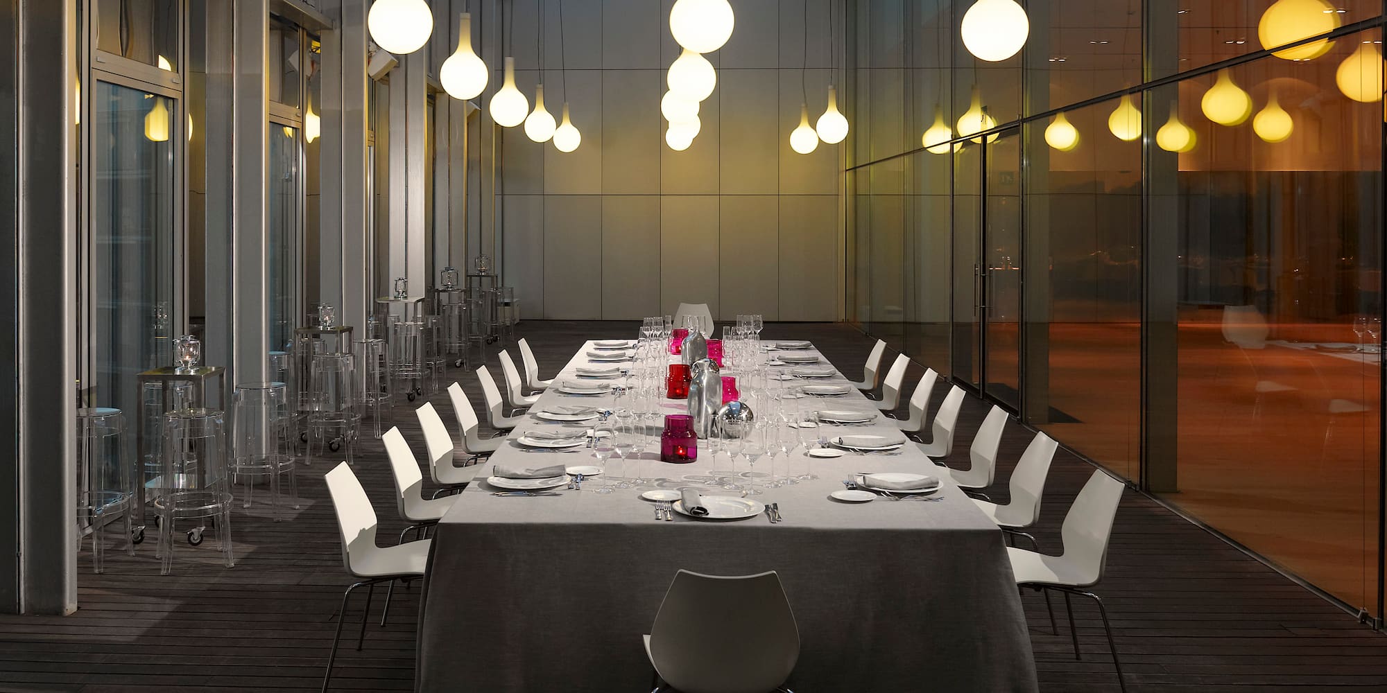 a long table with white chairs and a white tablecloth