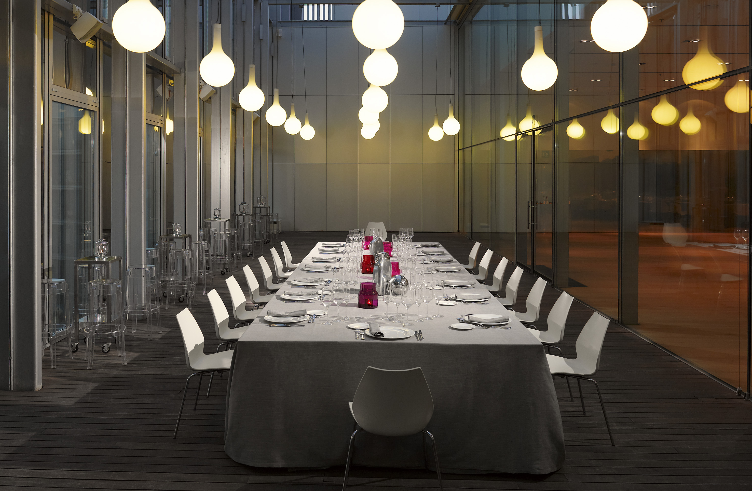 a long table with white chairs and a white tablecloth