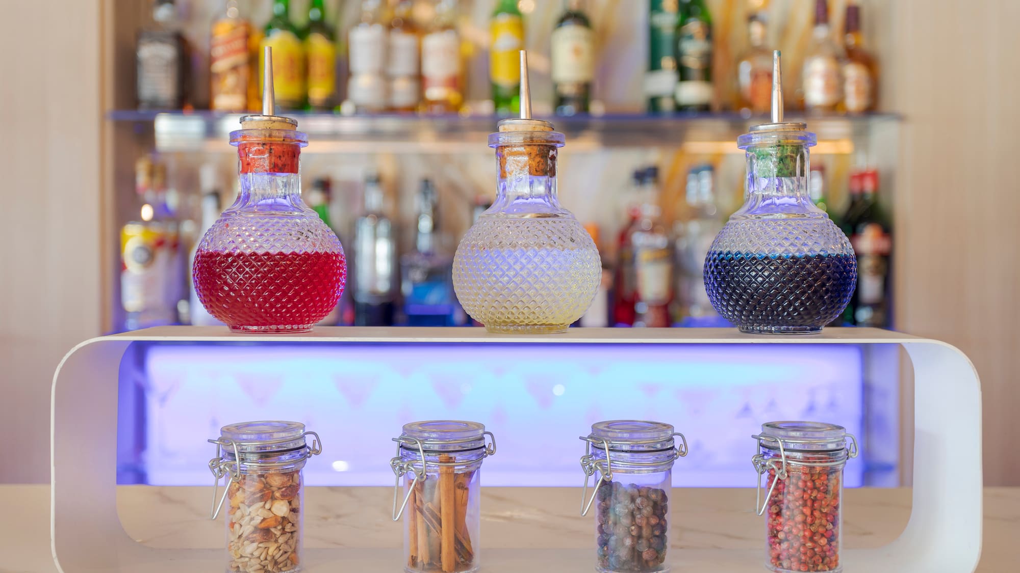 a group of glass jars with different colored liquid on a counter