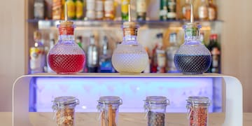 a group of glass jars with different colored liquid on a counter