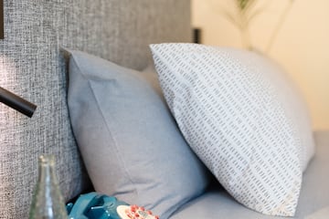 a bed with a telephone and a bottle of water on a table