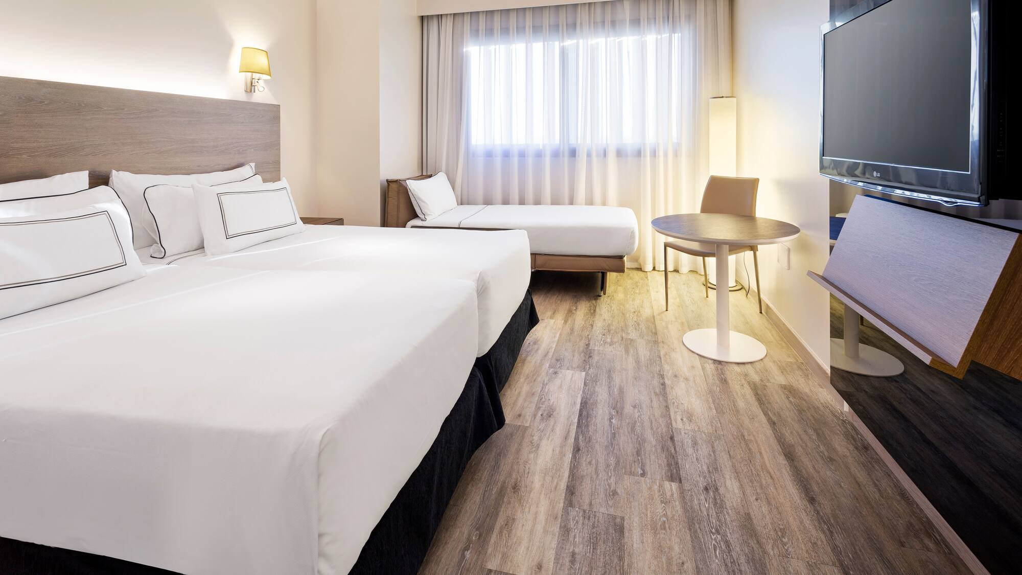 a room with two beds and a television