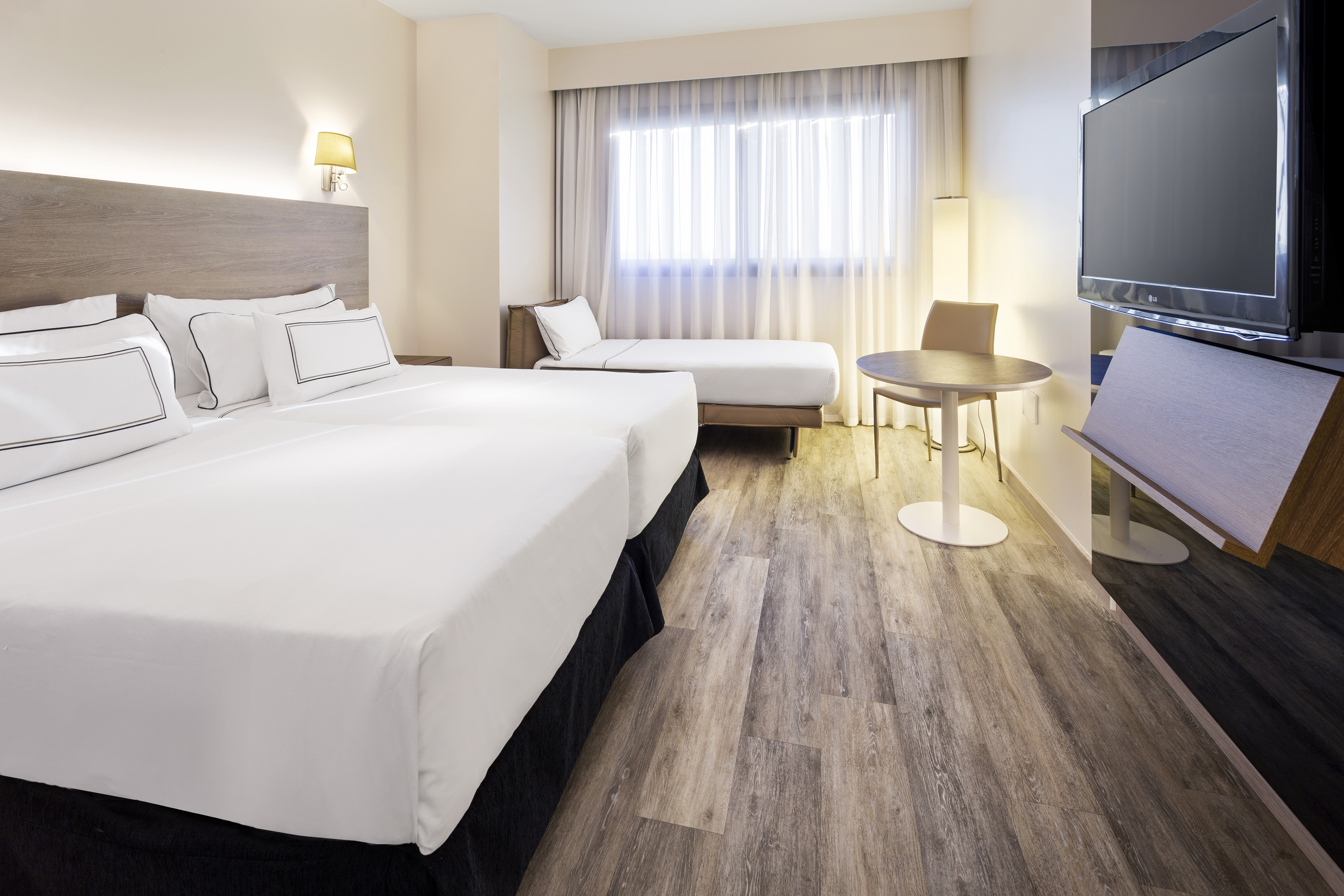 a room with two beds and a television