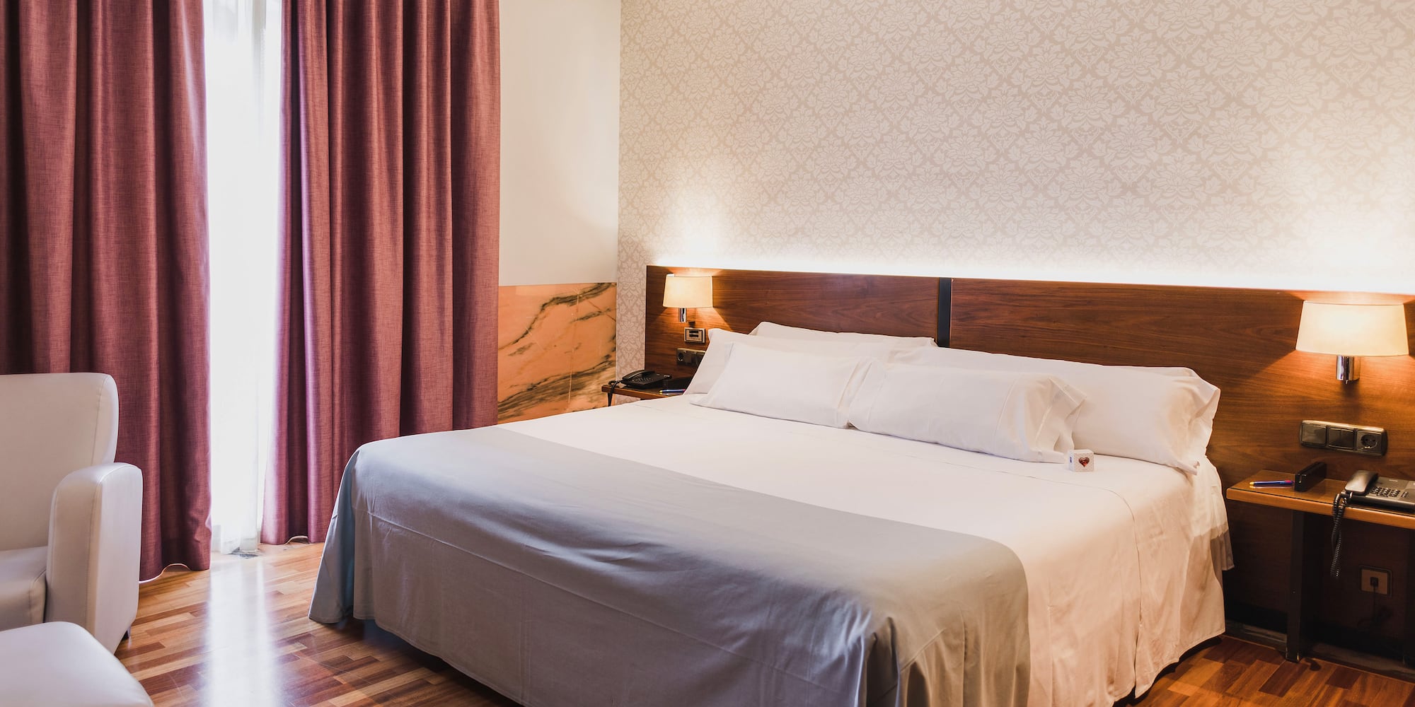 a bed with a wood headboard and a lamp