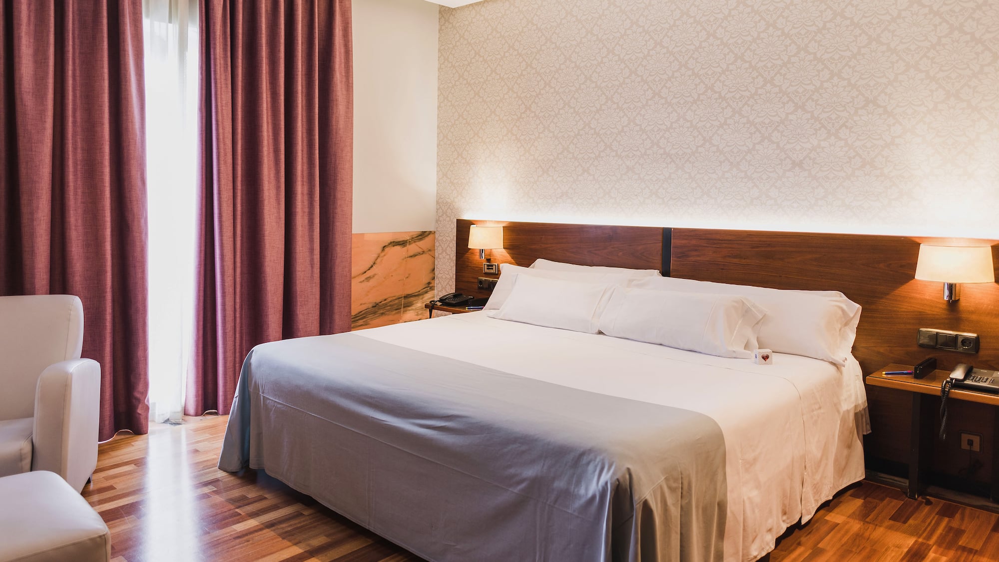 a bed with a wood headboard and a lamp