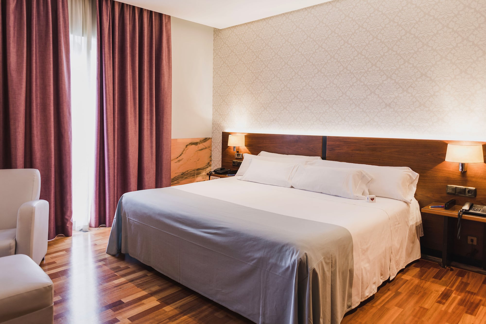 a bed with a wood headboard and a lamp