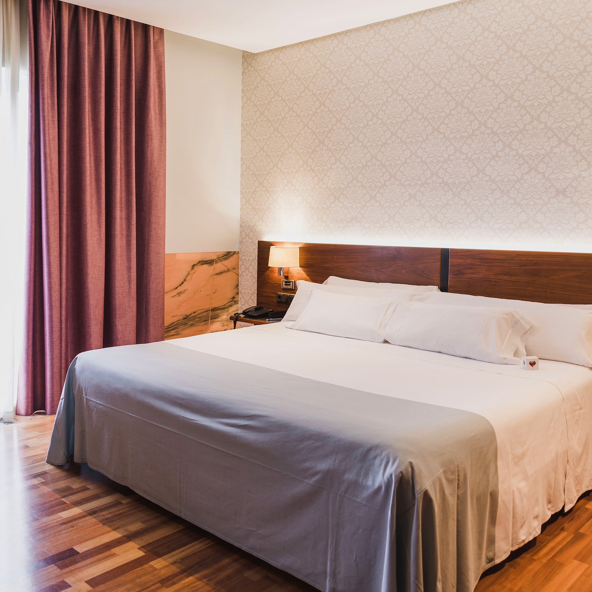 a bed with a wood headboard and a lamp