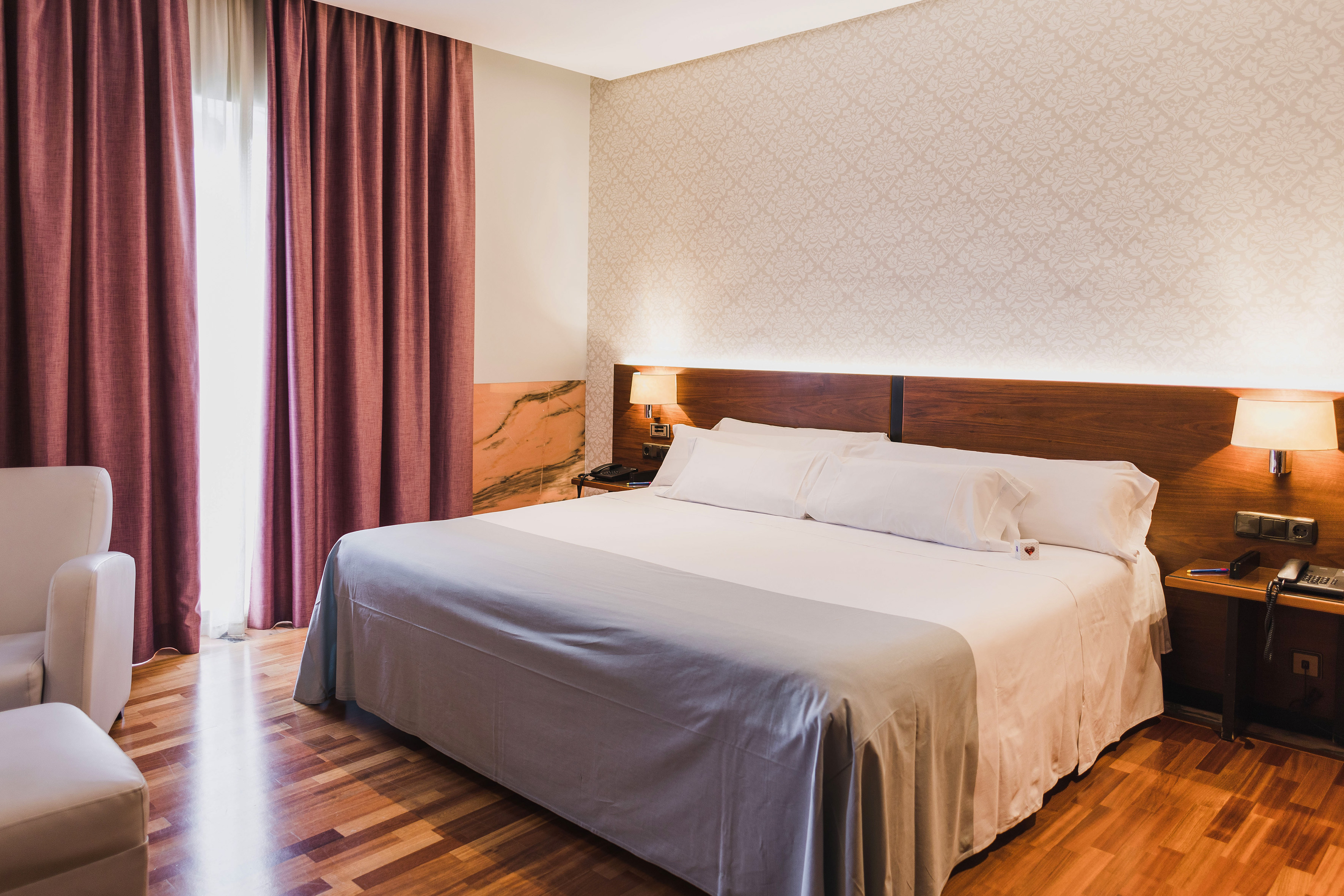 a bed with a wood headboard and a lamp