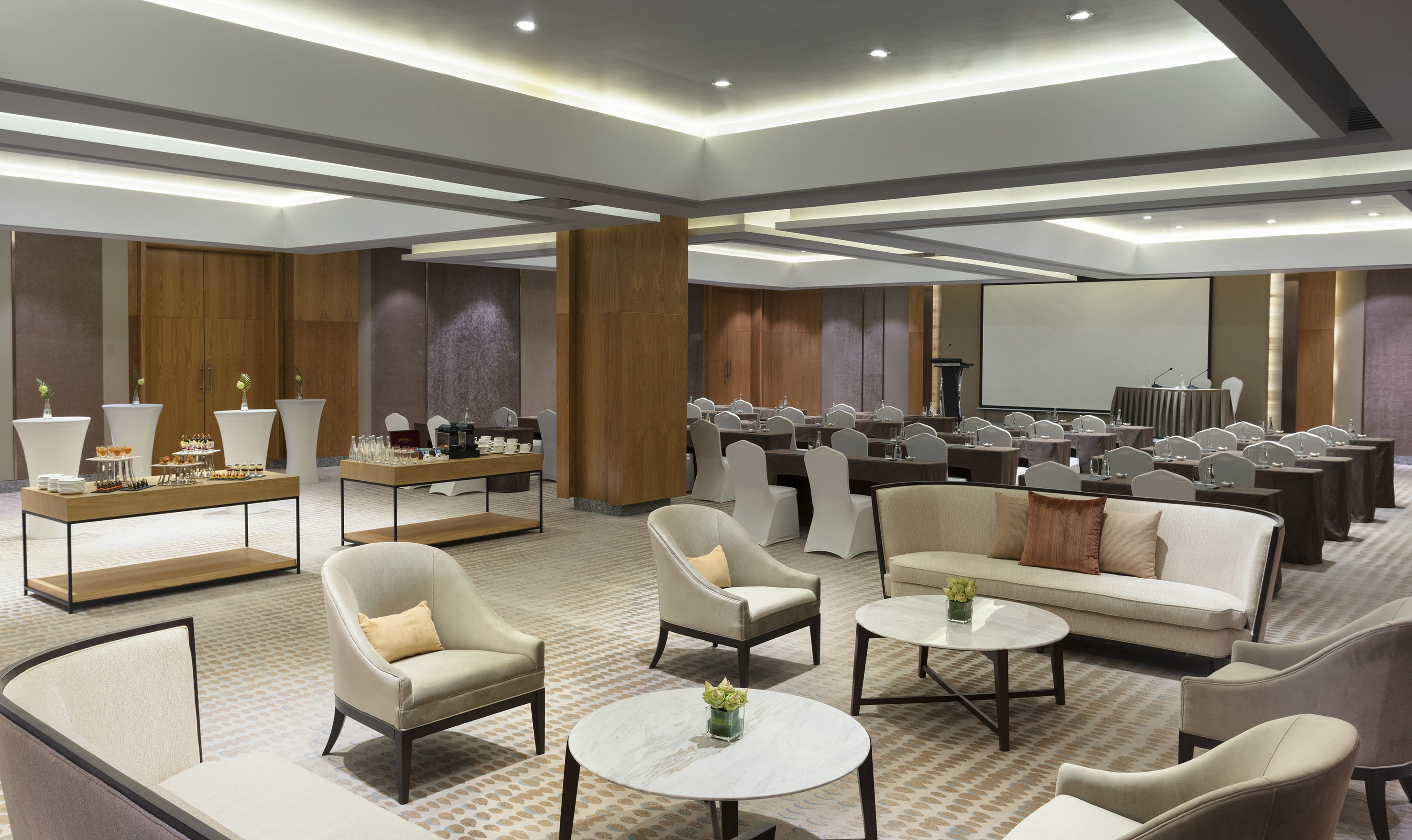 Professional meeting space with lounge, buffet, and presentation setup.