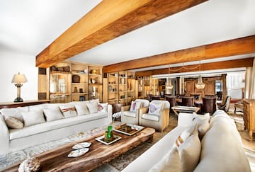 a living room with white couches and a wood table