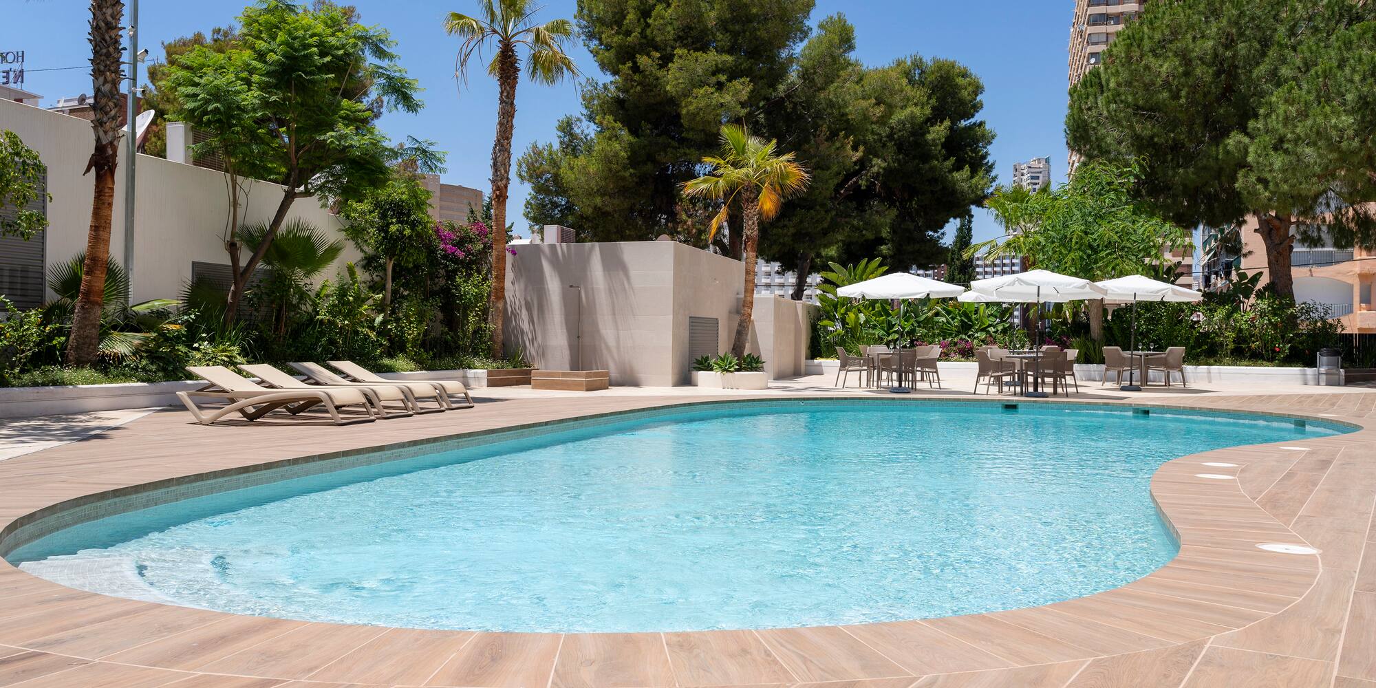 a pool with chairs and umbrellas in a hotel