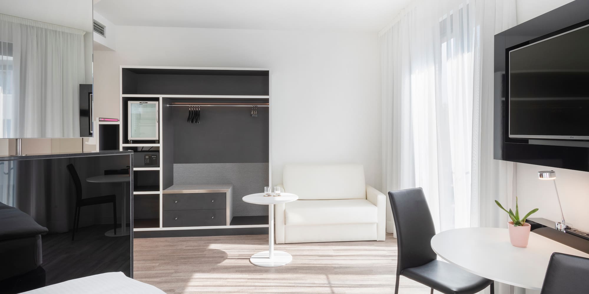 a room with a bed and a table and chairs