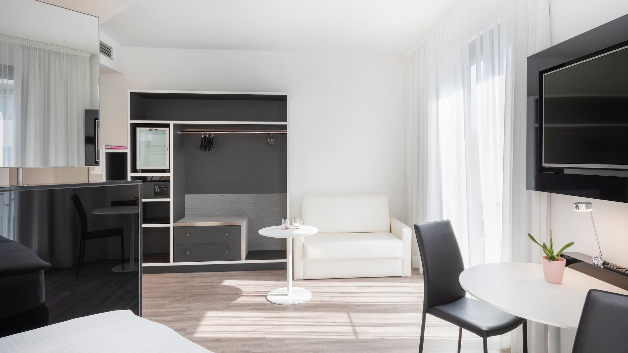 a room with a bed and a table and chairs