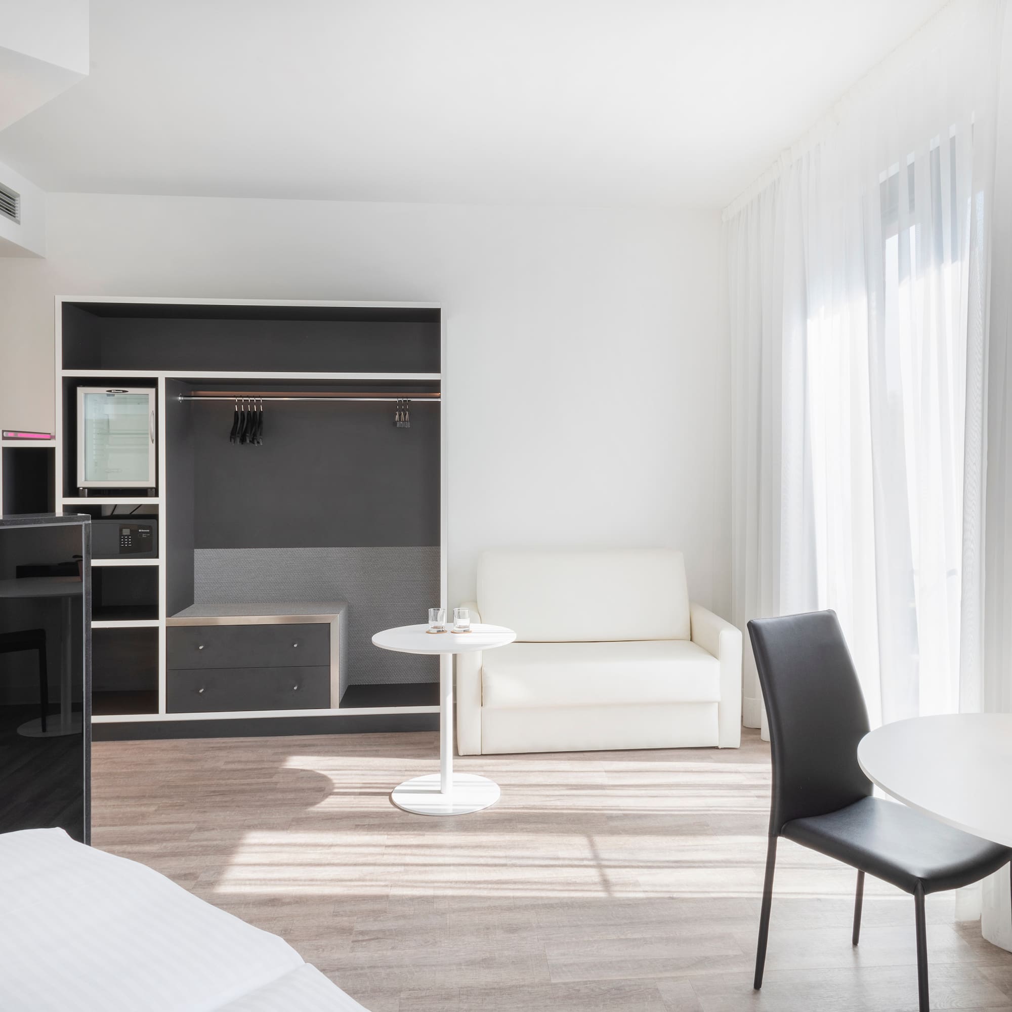 a room with a bed and a table and chairs