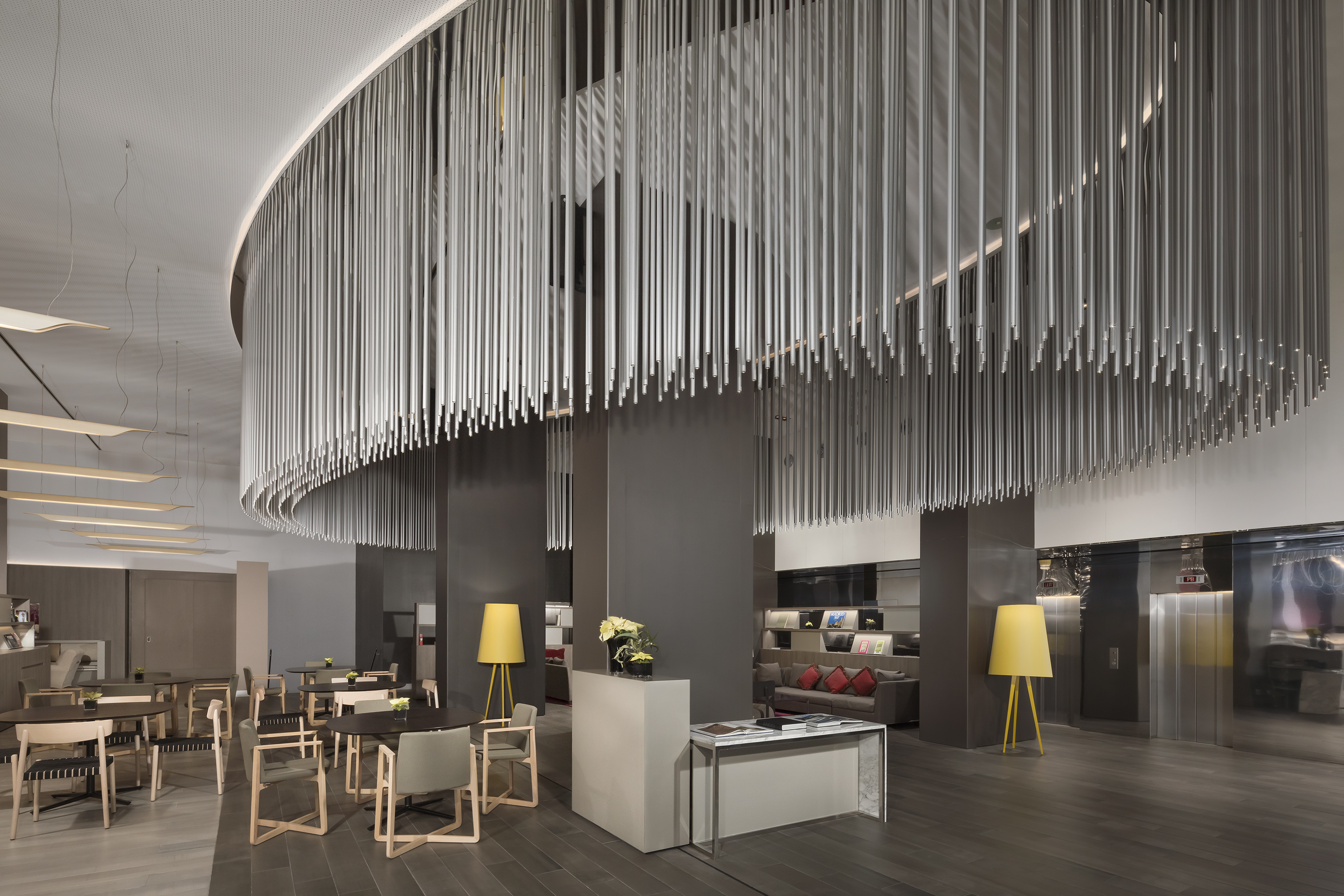 Modern hotel lobby with suspended rod ceiling and contemporary lounge seating.