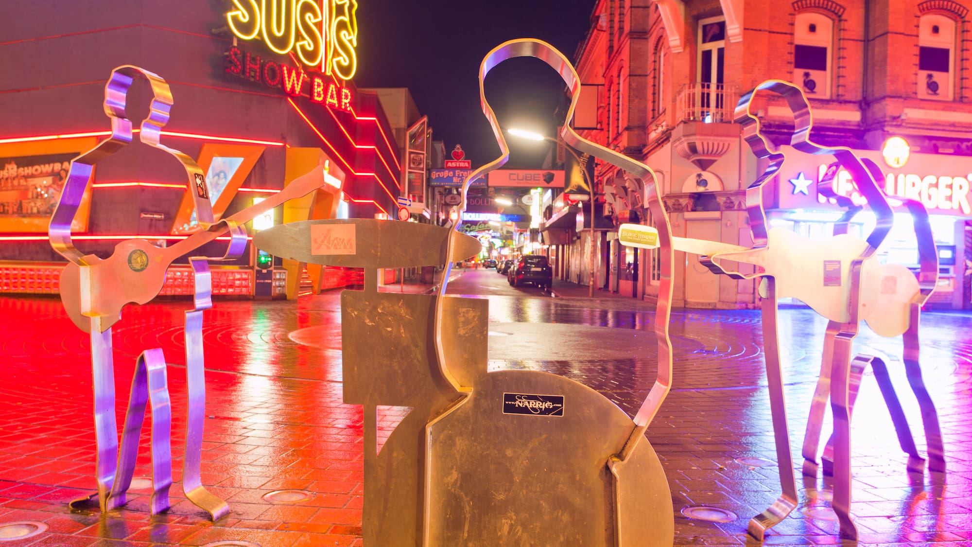 a group of metal statues on a sidewalk