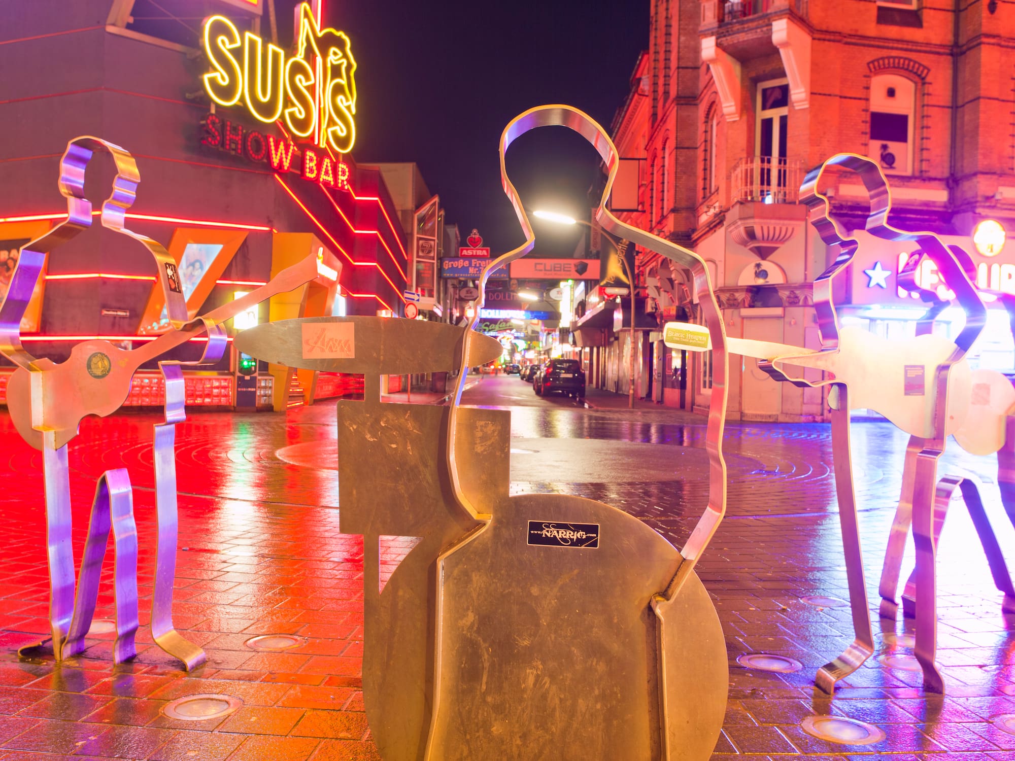 a group of metal statues on a sidewalk