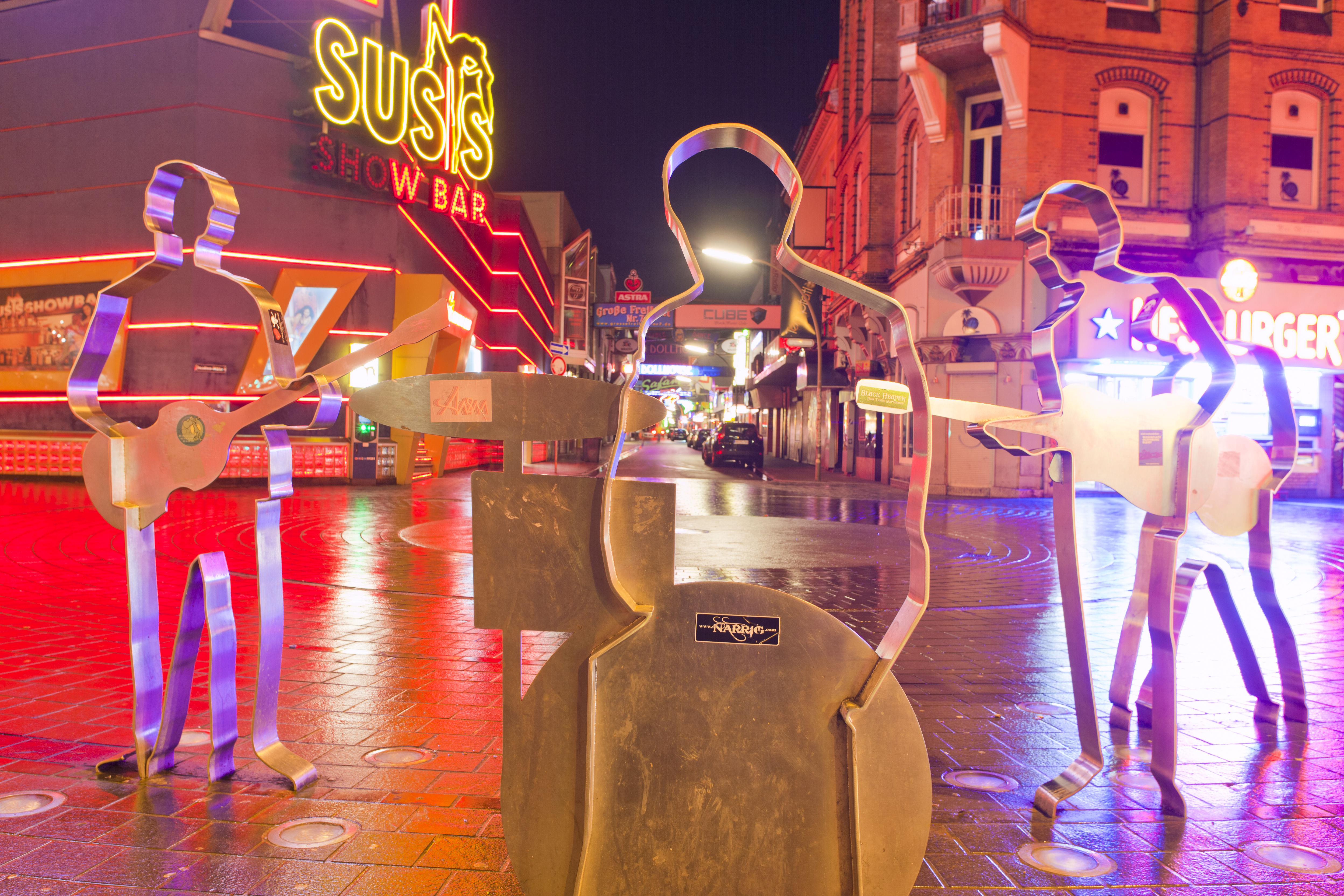 a group of metal statues on a sidewalk